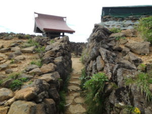 石積みの通路の奥に熊野神社の社殿がある。